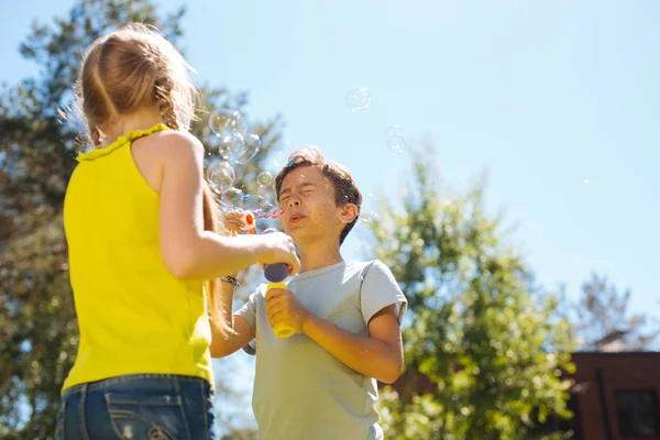 Contenido niños soplando burbujas de jabón — Foto de Stock