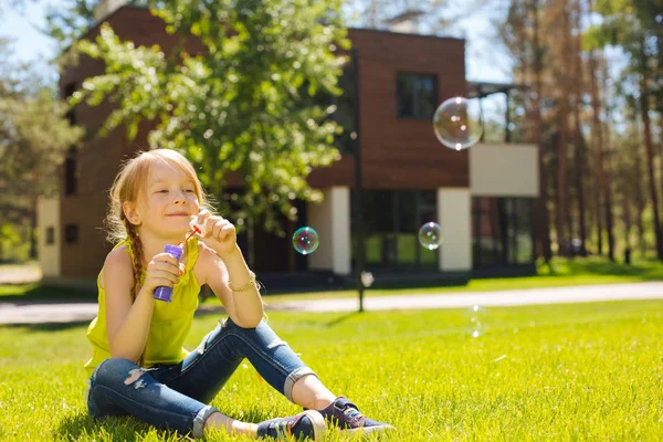 Chica alegre soplando burbujas de jabón — Foto de Stock
