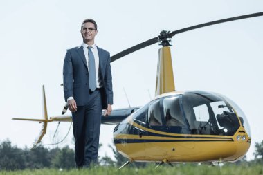 Helikopter pisti etrafında yürüyüş konuşurken gülümseyen hoş genç Ceo