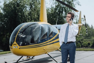 Telefona yakın helikopter konuşurken yakışıklı genç Ceo