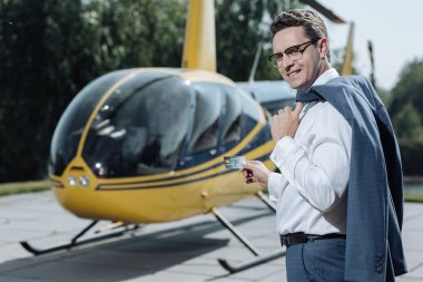 İyimser adam duran helikopter pisti, kredi kartı ile poz