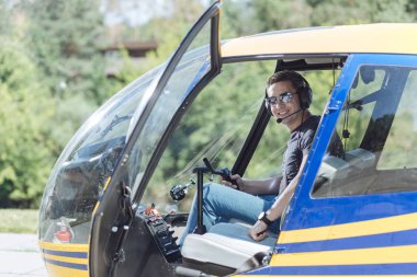Helikopter pilot kabininde oturan neşeli genç adam