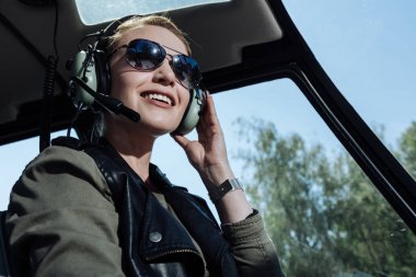 Neşeli helikopter pilotu hava trafik kontrolörü için dinlerken gülümseyen