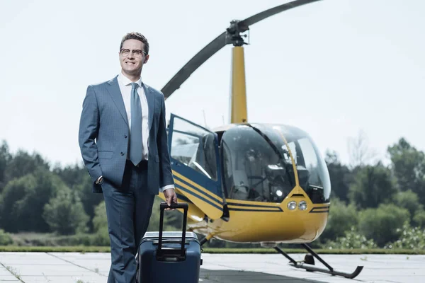 Charmante Ceo poseren met koffer op helikopterplatform — Stockfoto