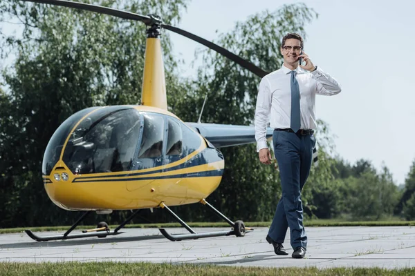 Vrolijke jonge Ceo bellen taxi vanaf helikopterplatform — Stockfoto