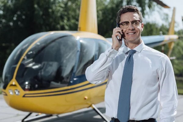 Vrolijke jonge zakenman communiceren met zijn partners op telefoon — Stockfoto