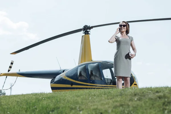 Joyful businesswoman talking on the phone during helipad inspection — Stock Photo, Image