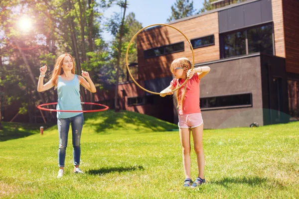 Piacevole madre e figlia hula-hooping al mattino — Foto Stock