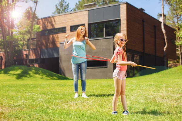 Glada mor och dotter leker med hula-hoops — Stockfoto