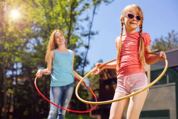 Hijita y su madre hula-hooping en la mañana — Foto de Stock