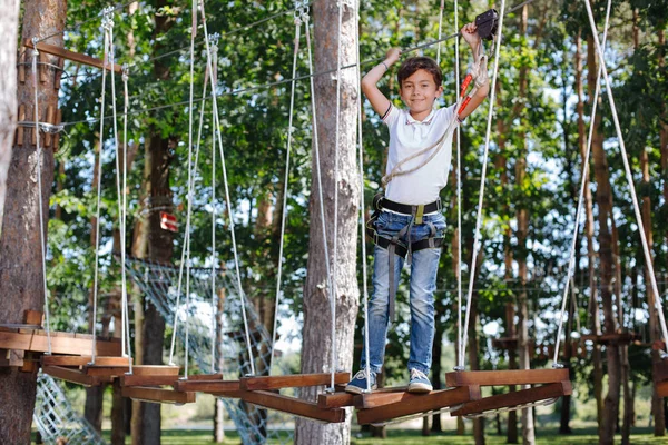 Upbeat preteen jongen die zich voordeed op touw park — Stockfoto