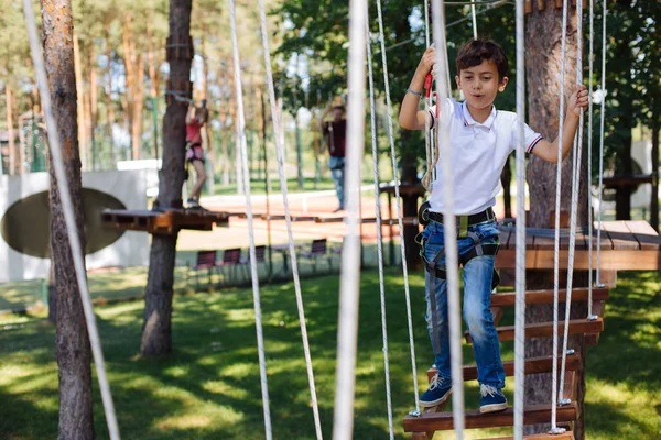 Aangenaam preteen jongen genieten van zichzelf op touw park — Stockfoto