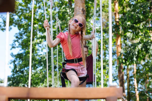 Niña alegre posando en un parque de cuerdas —  Fotos de Stock