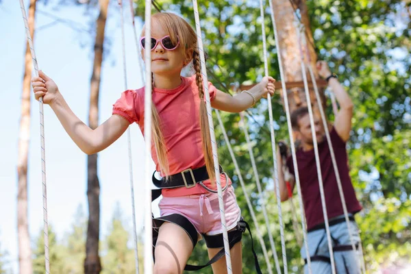 Encantadora niña disfrutando del día en el parque de cuerdas — Foto de Stock