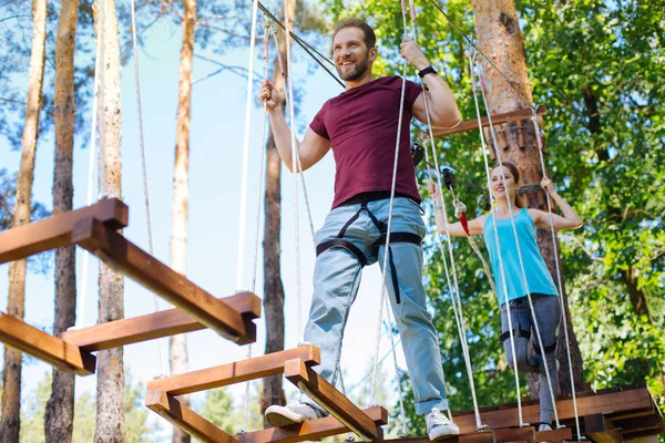 Cheerful young couple climbing at a rope park — Stock Photo, Image