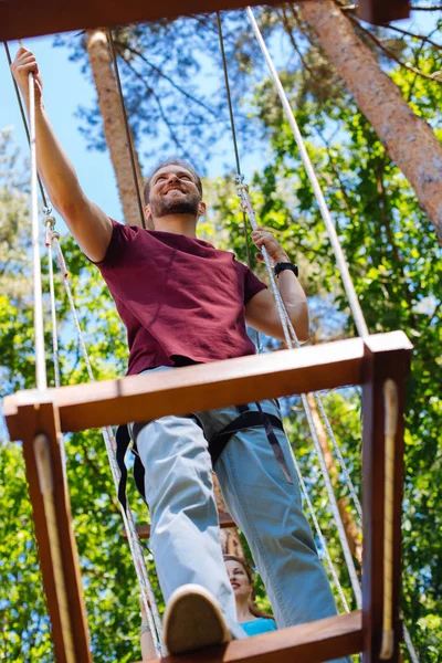 Knappe jonge man en zijn vriendin klimmen op touw park — Stockfoto