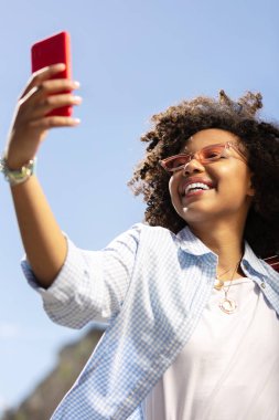 Selfies açık havada alırken poz neşeli kıvırcık kadın