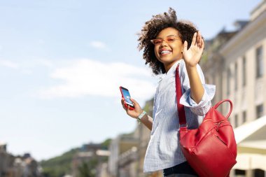 Hava tahmini kontrol ve sallayarak neşeli kıvırcık kadın