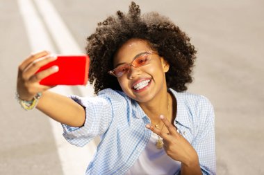Selfie alma ve neşeyle gülümseyen hoş genç kadın