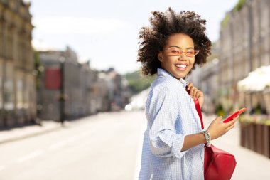 Sokaklarda telefon kullanırken poz sevimli kıvırcık kadın