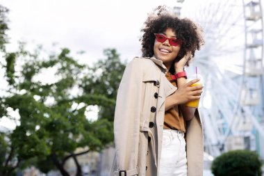 Parkta yürürken suyu sahip sevimli kıvırcık kadın