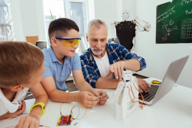 Neşeli akıllı öğretmen öğrenciler ile birlikte oturan