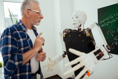 Ciddi adam robot önünde ayakta yaşlı