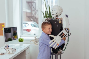 Neşeli mutlu çocuk bir robot sarılma