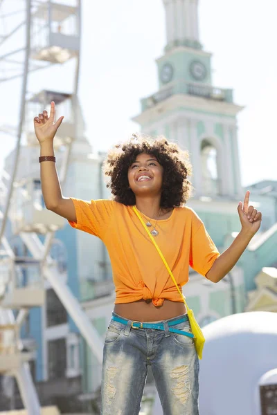 Neşeli kıvırcık kadının sokaklarda mutluluk dansı yapması