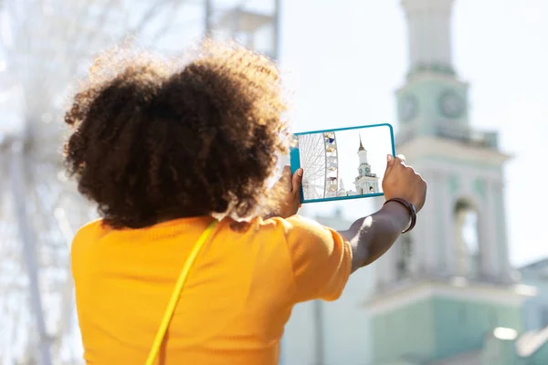 Lockigt kvinna att ta foto av bell tower och observation wheel — Stockfoto