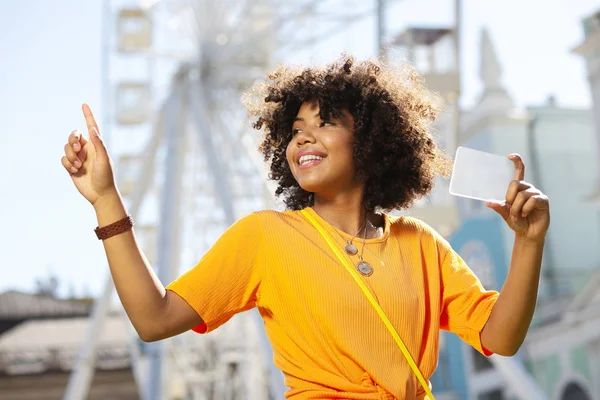 Kıvırcık saçlı kadın mutlu bir şekilde fotoğraf çekmek