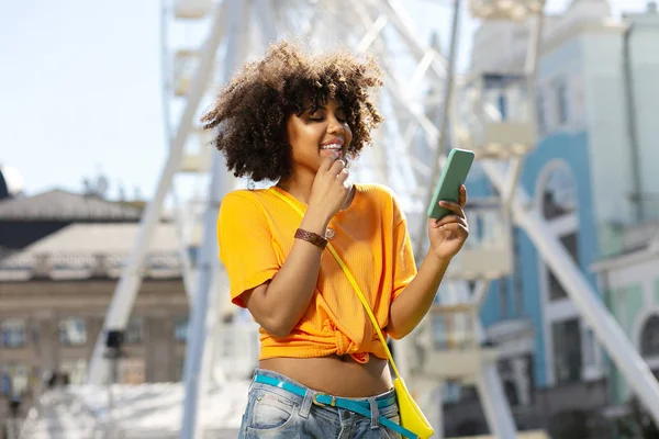 Upbeat ung kvinna Kontrollera meddelanden medan sightseeing — Stockfoto