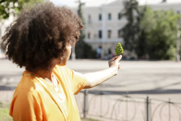 Curly-haired young woman holding tree model — Stock Photo, Image