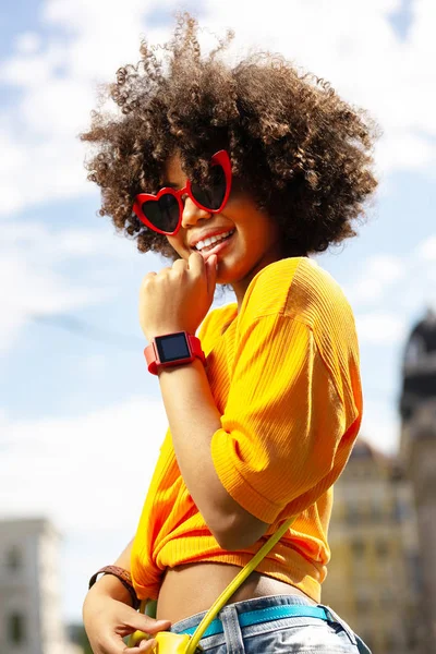 Upbeat lockigt kvinna bär hjärtformade solglasögon — Stockfoto