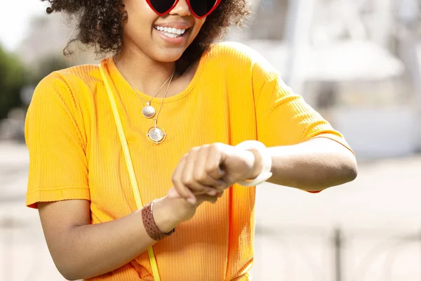 Aangename krullend vrouw controleren haar horloge — Stockfoto