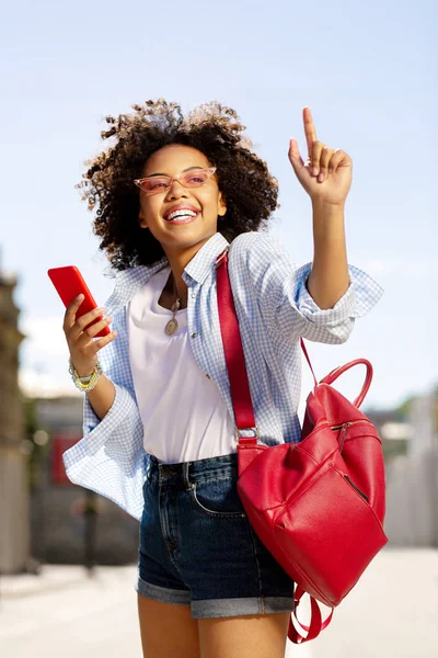 Mesajları kontrol ve onun parmak yükselterek iyimser kıvırcık kadın