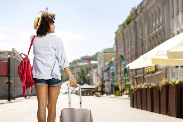 Yürüyüş ve bavul taşıma ince kıvırcık kadın