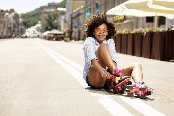 Χαριτωμένο σγουρά κορίτσι βάζοντας με πατίνια στο δρόμο — Φωτογραφία Αρχείου