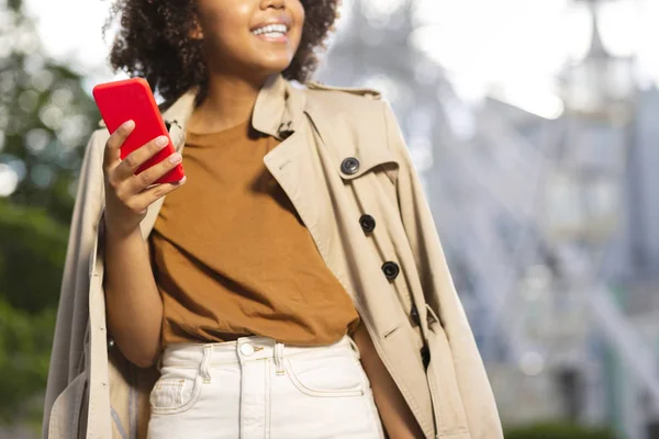 Veselá mladá žena držící smartphone v červený kufřík — Stock fotografie