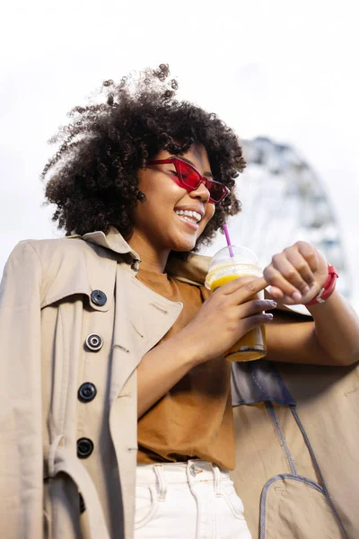 Neşeli genç kadın arkadaşlar için beklenirken saat denetimi