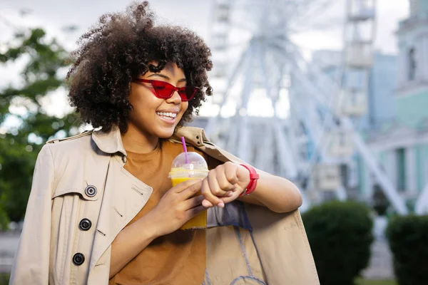 Söta lockigt kvinnan väntar vän och dricka saft — Stockfoto