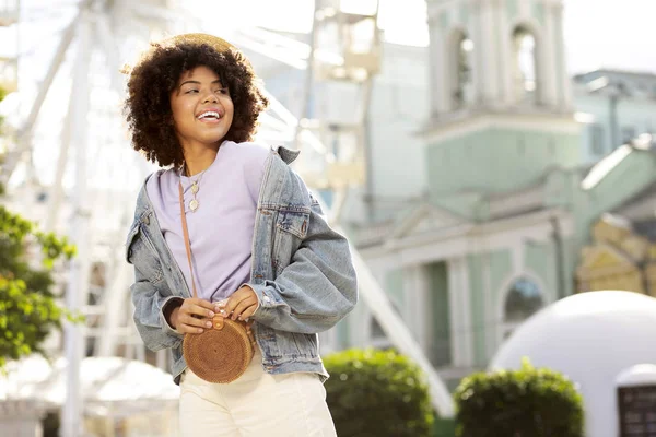 Fille bouclée dans une tenue hippie souriant dans les rues — Photo