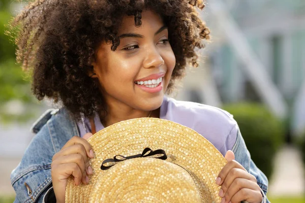 Glada curly girl innehar en stråhatt — Stockfoto