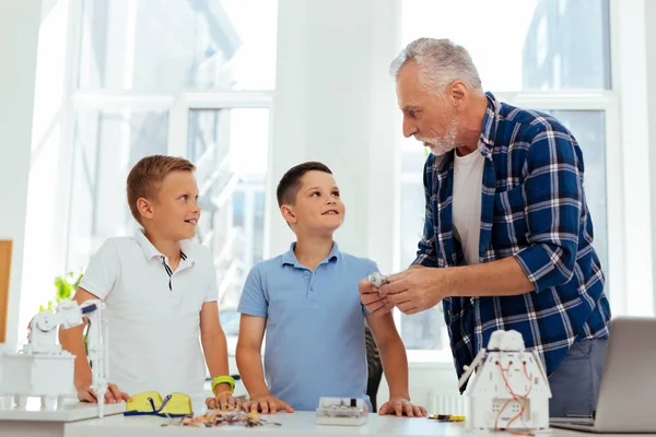 Positivo ragazzi intelligenti guardando il loro nonno — Foto Stock