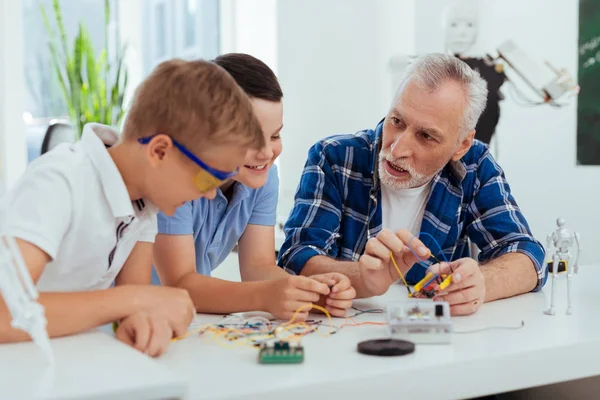 Хороший розумний чоловік навчає своїх онуків — стокове фото