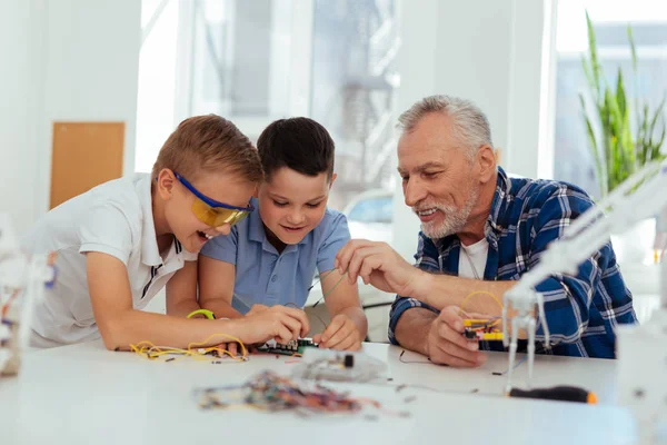 Positivo insegnante gioioso aiutare i suoi alunni — Foto Stock