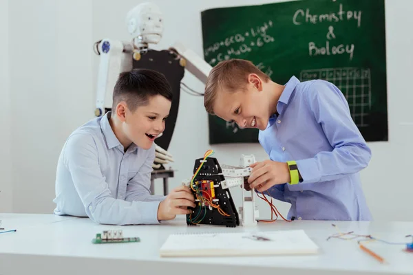 Lindos chicos alegres mirando al robot — Foto de Stock