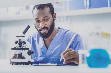 Rapor yazma mavi üniformalı genç biyolog