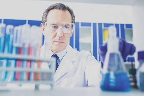 Químico anciano con guantes azules trabajando en la investigación — Foto de Stock
