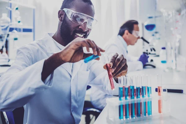 Bearded physician smiling while enjoying process of work